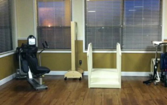A room with exercise and rehabilitation equipment, including a stationary bike and therapy stairs.