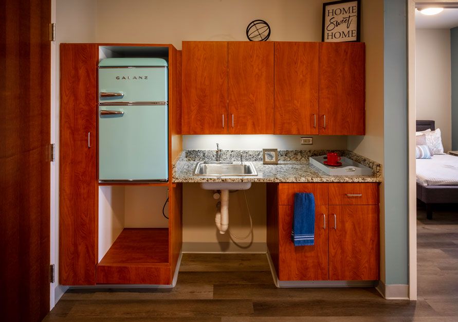 A retro-style kitchen setup with wooden cabinets and a vintage fridge.