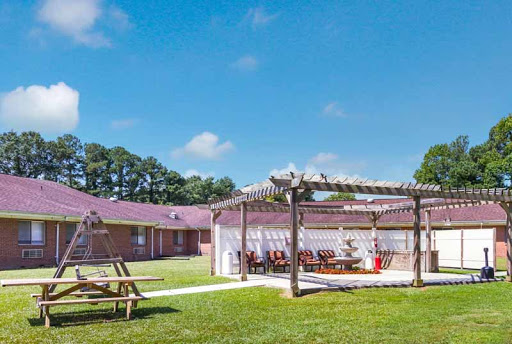 A serene outdoor dining area with a pergola, inviting guests to enjoy a meal in the sunshine.