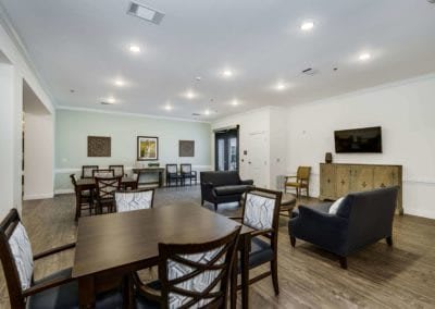A modern living space featuring multiple dining tables and comfortable seating with stylish decor.