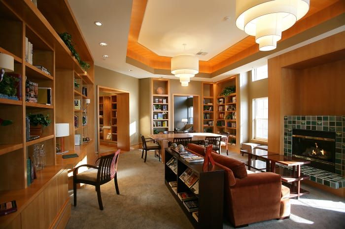 A cozy library with bookshelves, comfortable seating, and warm lighting.