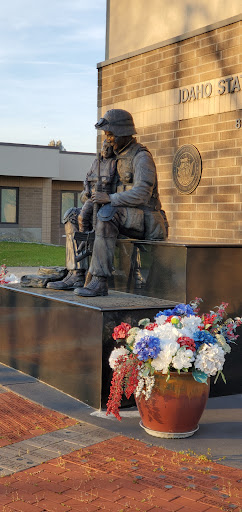 A heartfelt memorial statue honoring veterans, adorned with colorful flowers.
