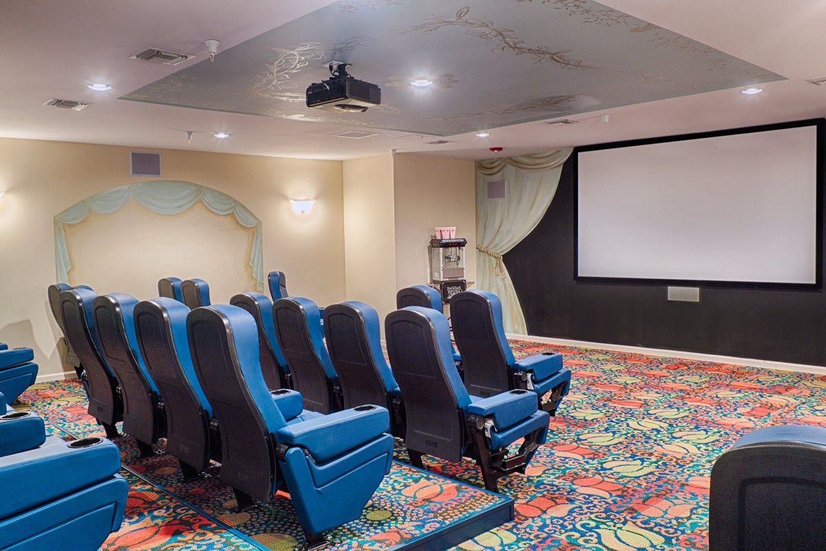 A cozy home theater room with blue seating and a projector screen.
