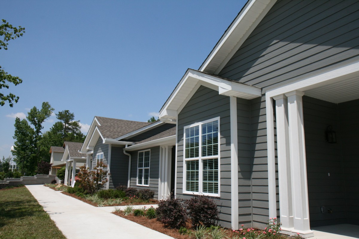 A row of modern suburban homes with neatly maintained gardens and walkways.