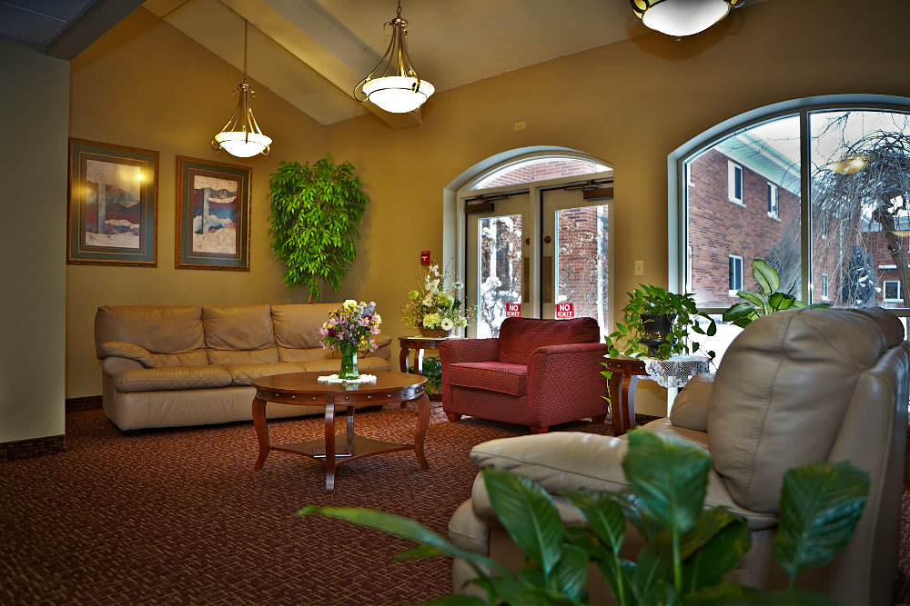 A cozy living room with comfortable seating and lush plants.