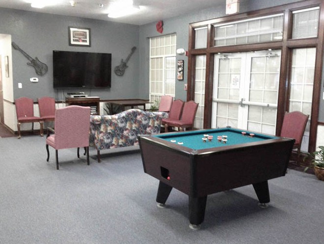 A cozy game room with a pool table and seating area.