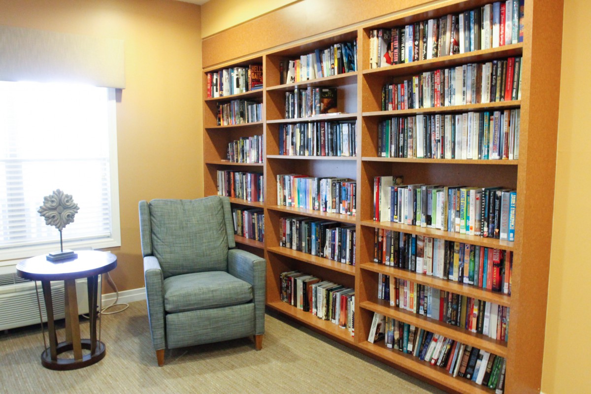 A cozy library corner with bookshelves filled with books and an armchair for reading.