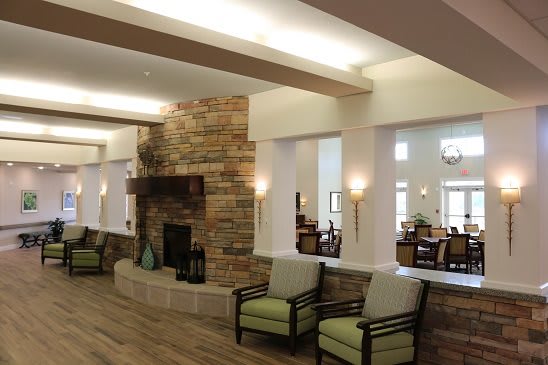 A modern living room interior with a stone fireplace and comfortable seating.