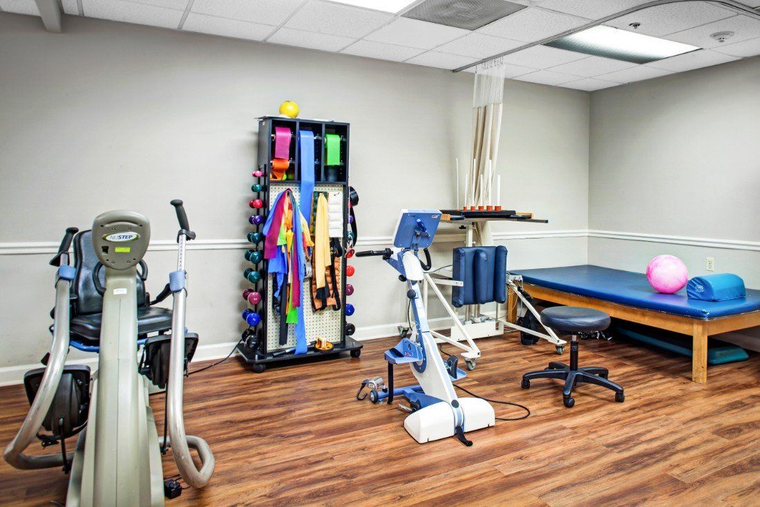 A well-equipped physical therapy room with various exercise and rehabilitation equipment.