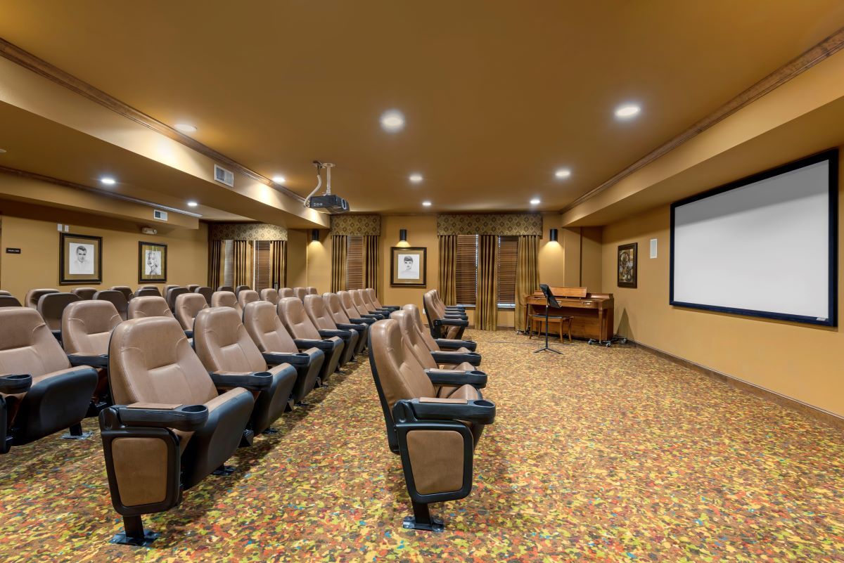 A cozy indoor theater with rows of comfortable seating facing a large screen.
