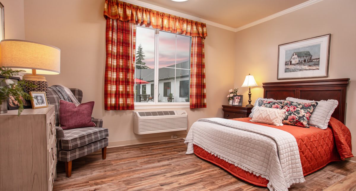 A cozy bedroom with warm-toned curtains and a neatly made bed.