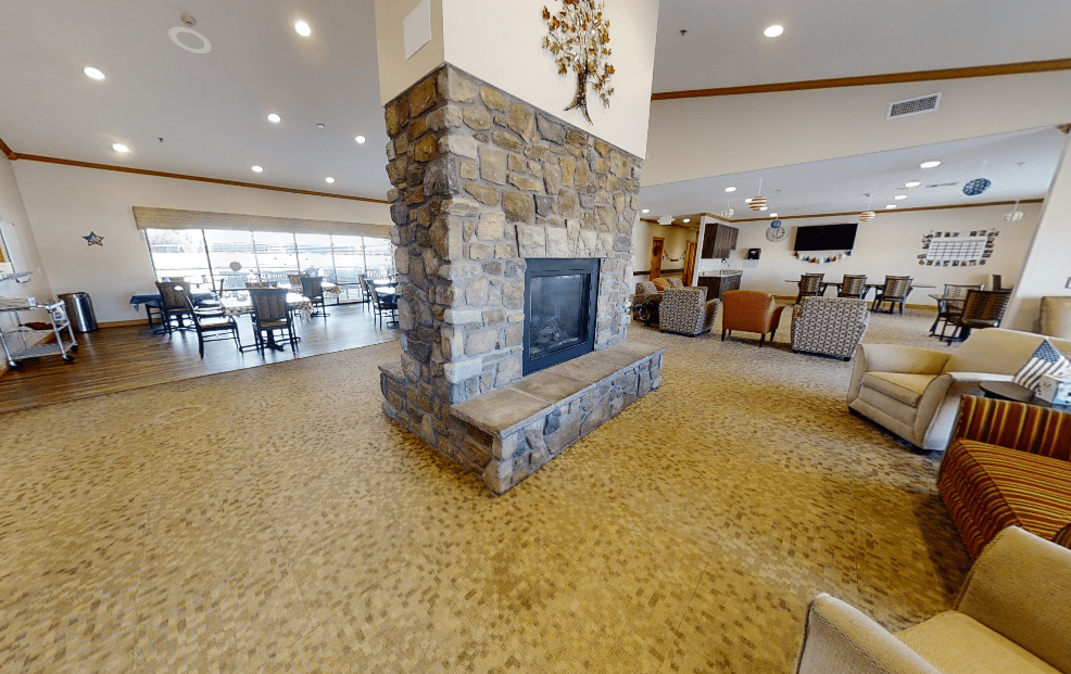 A spacious modern interior featuring a stone fireplace and comfortable seating areas.