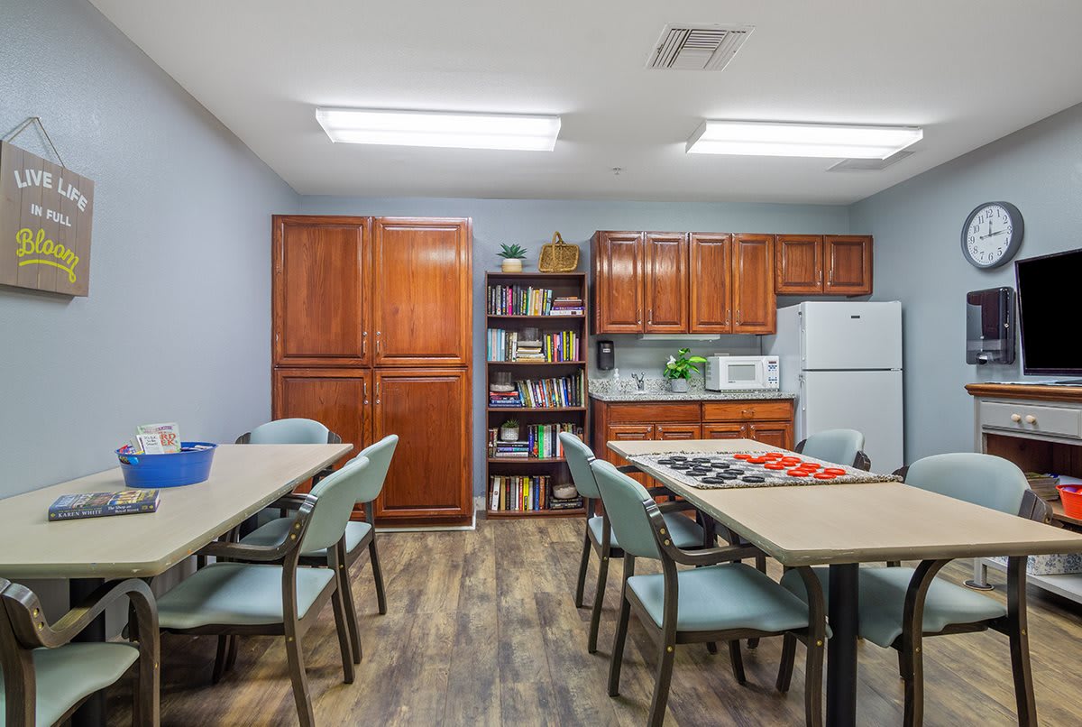 A well-organized break room with tables, chairs, and kitchen appliances.