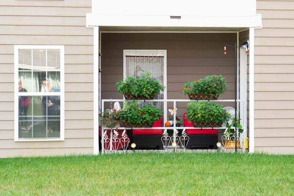 A cozy residential balcony with potted plants and outdoor seating.