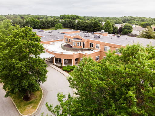 Aerial view of a modern healthcare facility surrounded by lush greenery.