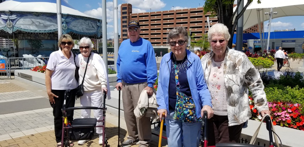 A group of seniors enjoying a day out together, using walking aids.