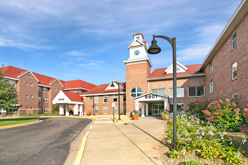 A charming residential building featuring a clock tower and landscaped surroundings.