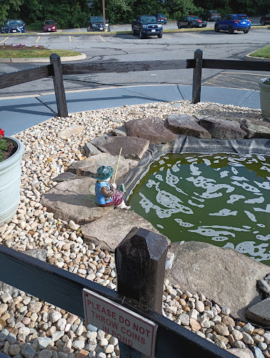 A charming fishing-themed pond featuring a decorative statue patiently casting a line.