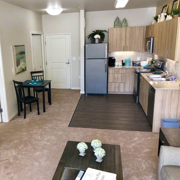 A modern apartment interior featuring a compact kitchen, dining table, and cozy living area.