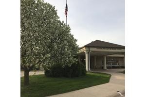 A building with a flowering tree and an American flag nearby.