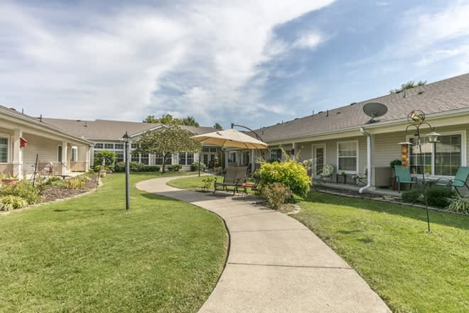 A peaceful residential courtyard with a walkway, garden, and patio area.