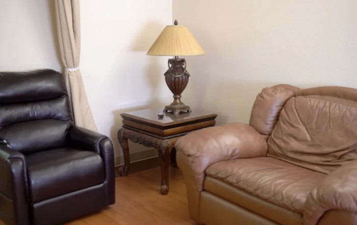 A cozy living room corner with a lamp on a wooden coffee table between two sofas.