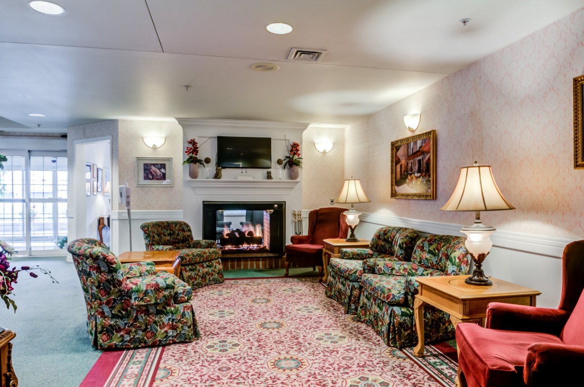 A cozy living room with a fireplace, sofas, armchairs, and various decor elements.
