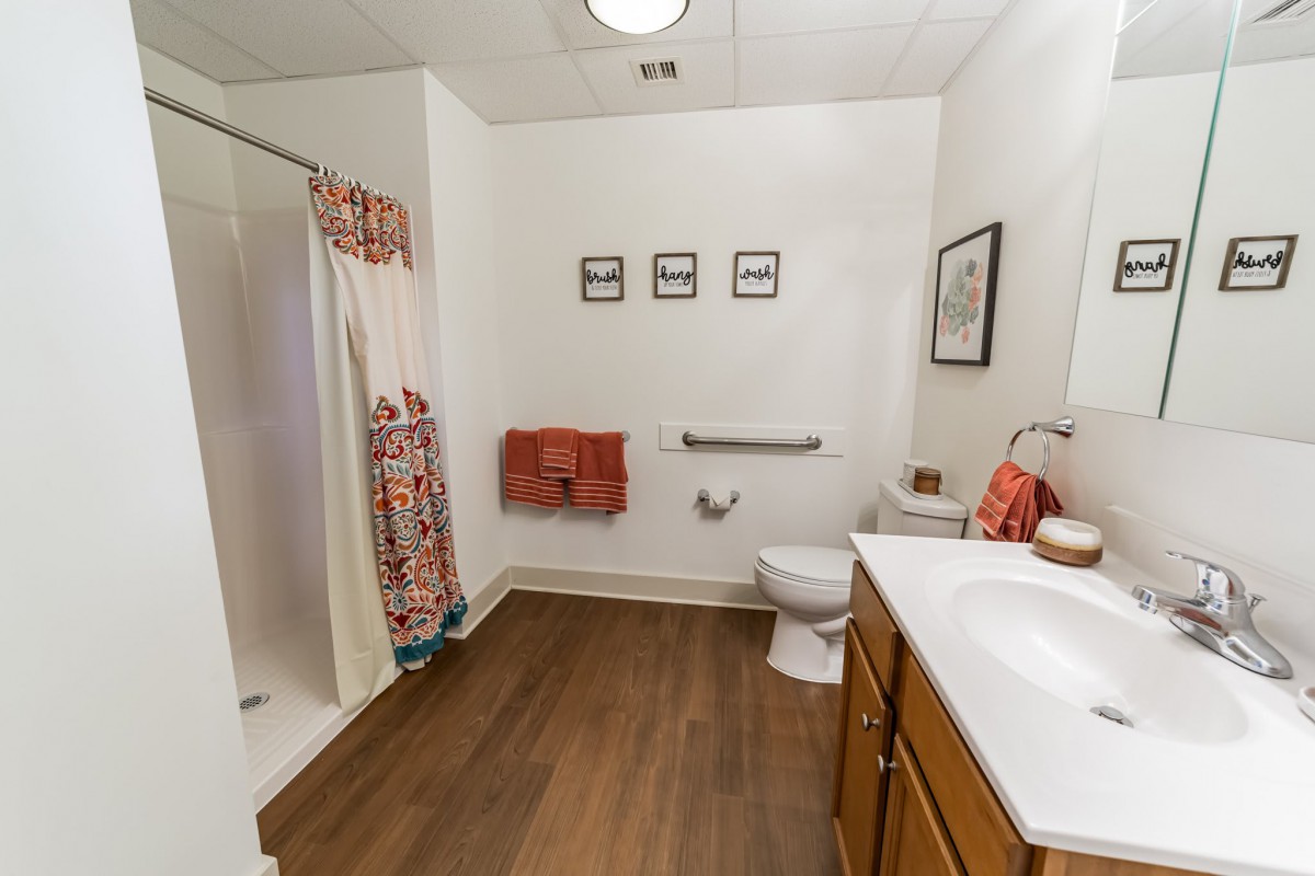A clean and well-decorated bathroom with a shower, sink, and toilet.