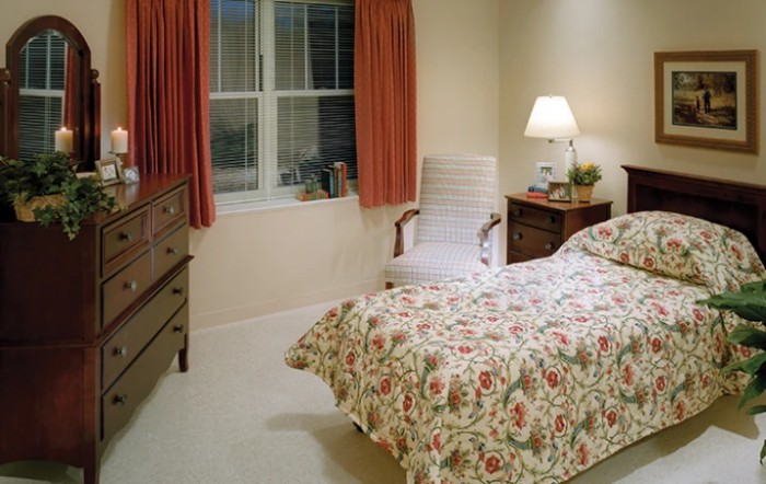 A cozy bedroom with floral bedding and soft lighting.