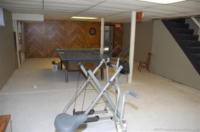 A home basement with exercise equipment and a ping pong table.