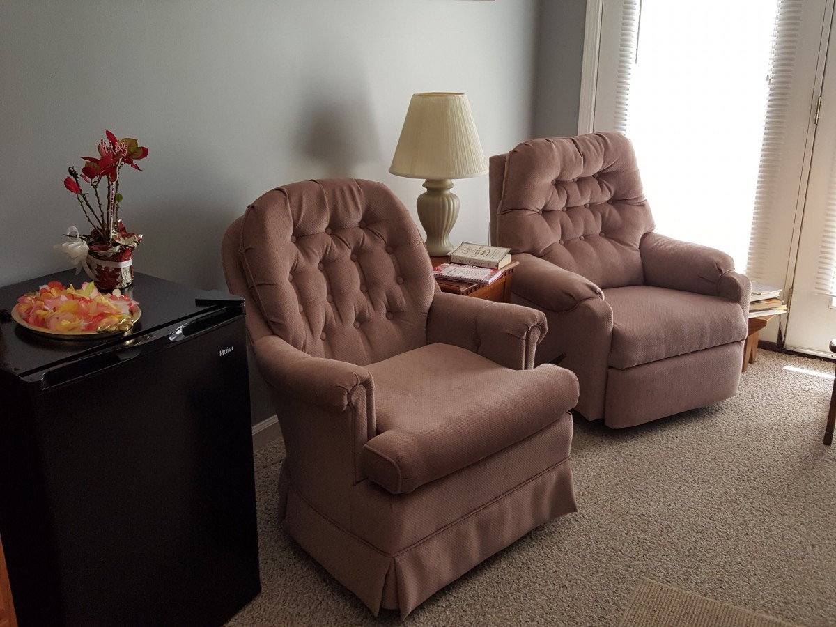 A cozy living room setup featuring two plush armchairs and a lamp.