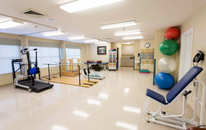 A spacious rehabilitation center equipped with various exercise and therapy equipment.