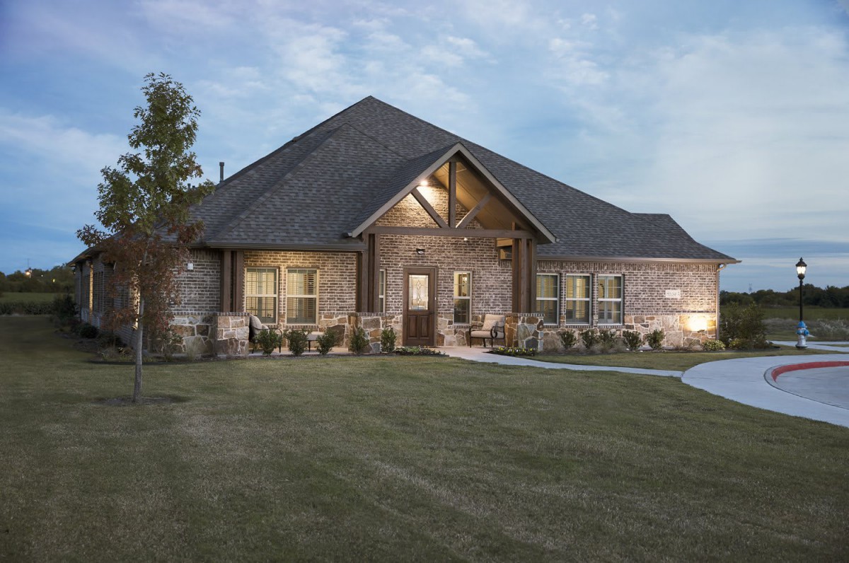 A beautiful brick house with a well-maintained lawn at dusk.