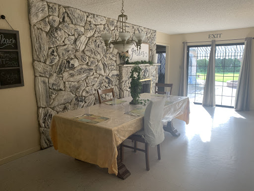 A bright and inviting dining room featuring a rustic stone wall and elegant wooden furniture.