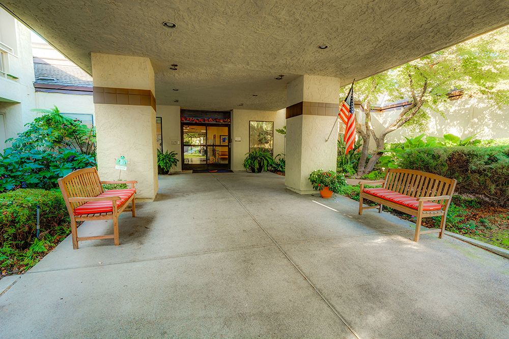 The entrance to a building with benches and an American flag.