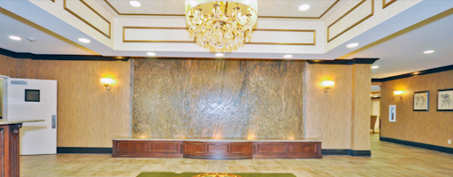 A luxurious hotel lobby featuring an elegant chandelier and a decorative waterfall.