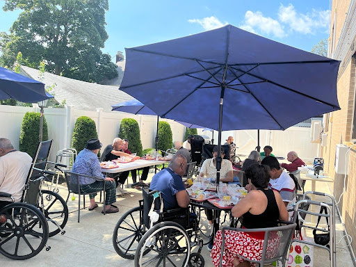 Seniors enjoying a meal together in a sunny outdoor setting.
