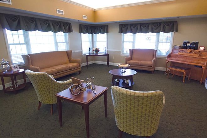 A cozy living room with comfortable seating and natural light from large windows.