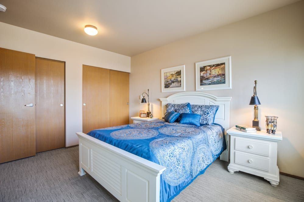 A cozy bedroom with blue bedding and stylish decor.