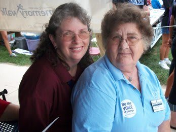 Two women smiling at an outdoor event.