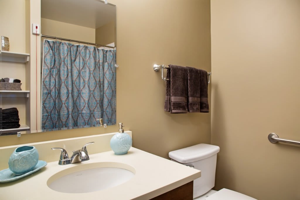 A clean and well-organized bathroom with a sink, toilet, and shower area.