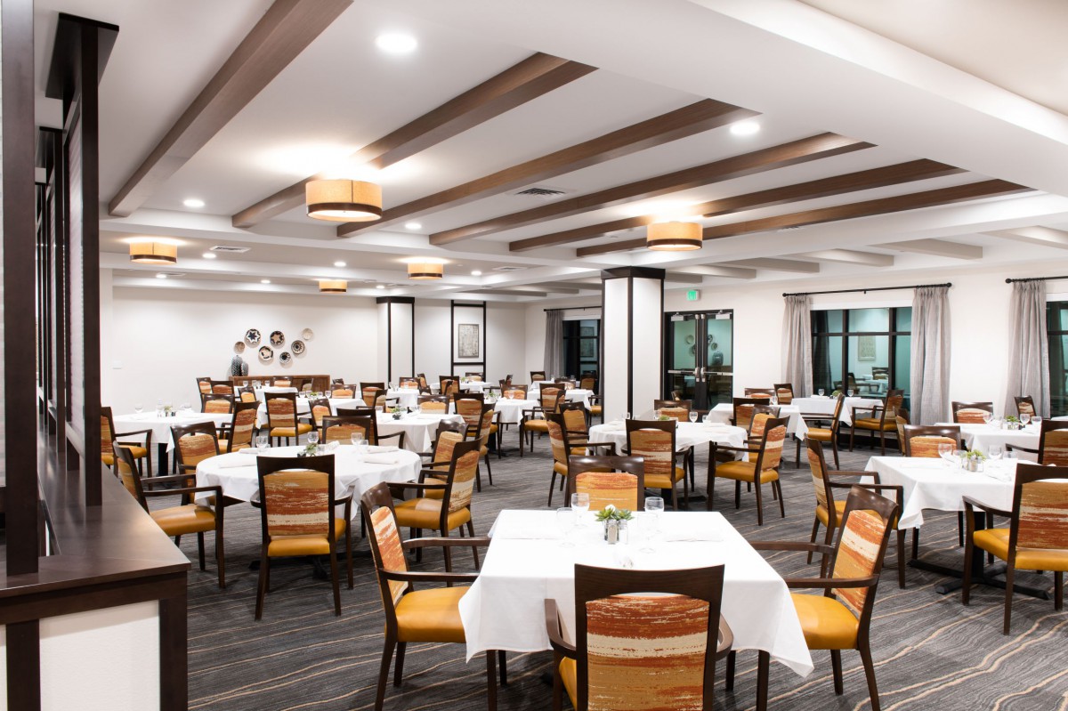 A modern and elegantly designed restaurant dining area with neatly arranged tables and chairs.