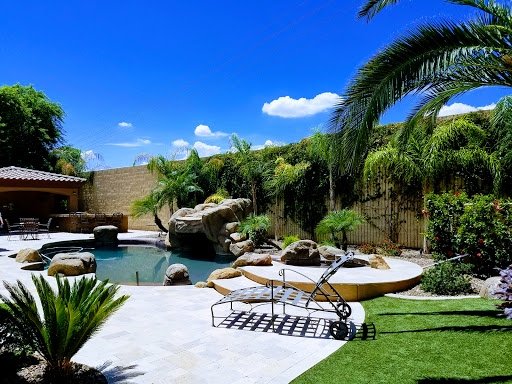 A tranquil backyard oasis featuring a sparkling pool surrounded by lush greenery and comfortable lounging areas.