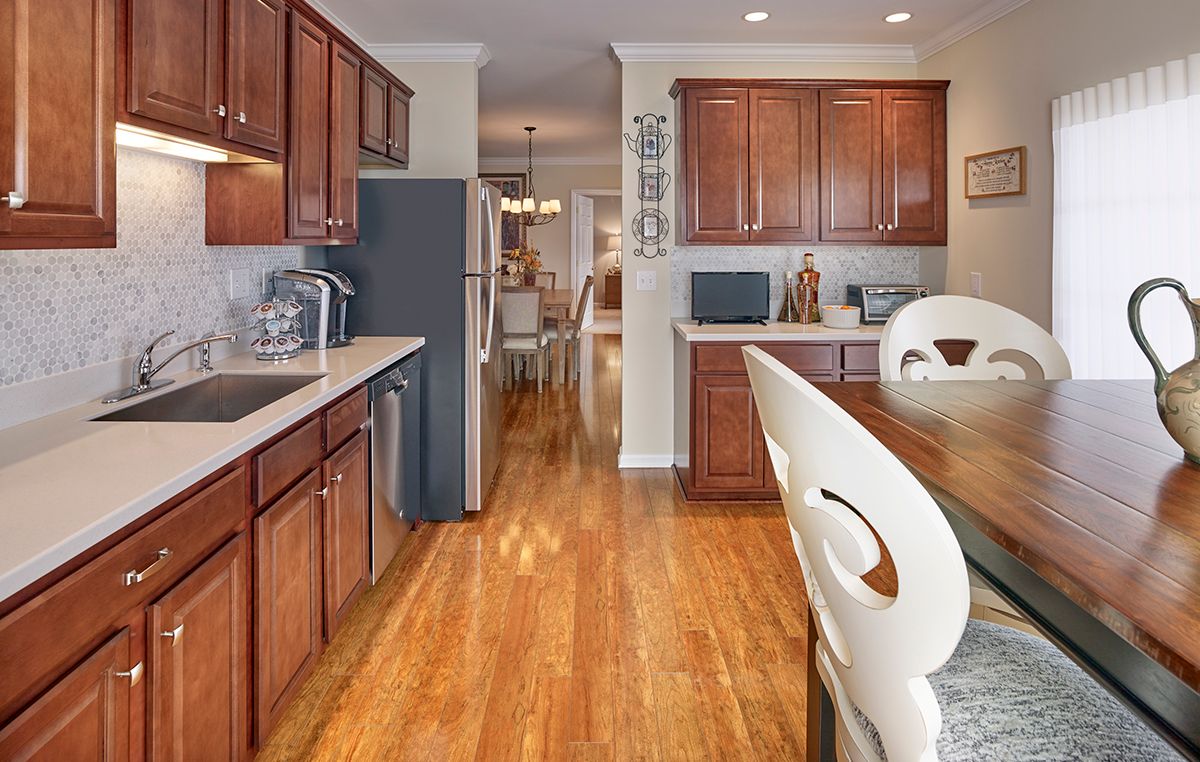 A modern kitchen with wooden cabinets and a hardwood floor.