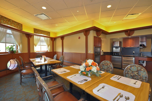 A cozy dining room featuring elegant wooden furniture, a tasteful table setting with flowers, and inviting warm lighting.