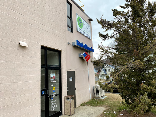 View of a storefront featuring a business sign and a flag.