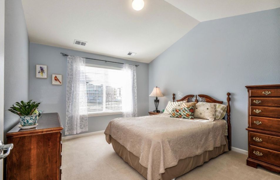 A cozy bedroom with a large window letting in natural light.