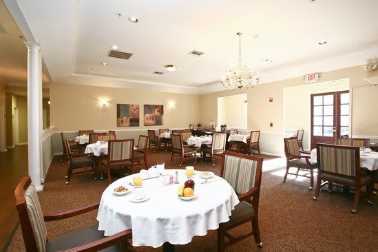 A cozy dining room with round tables and elegant table settings.