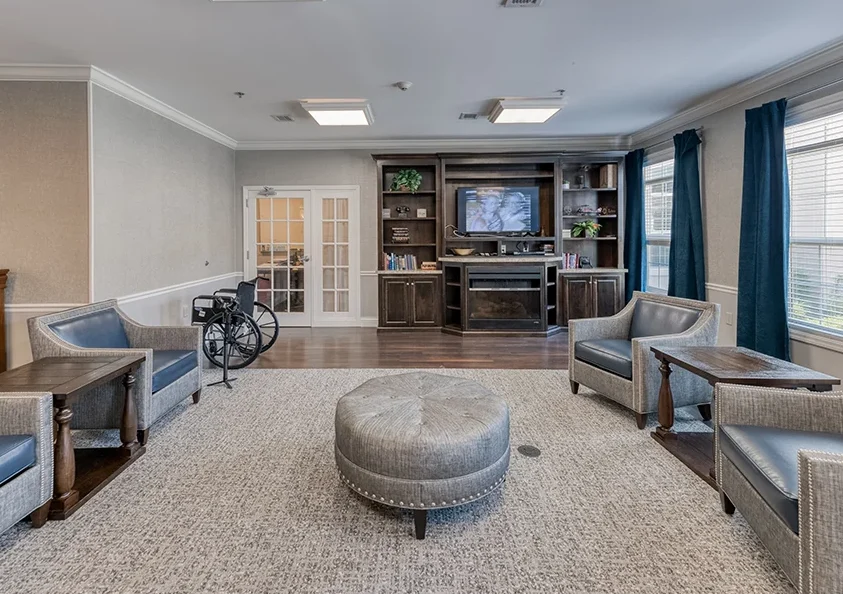A modern living room with comfortable seating, a bookshelf, and a television.