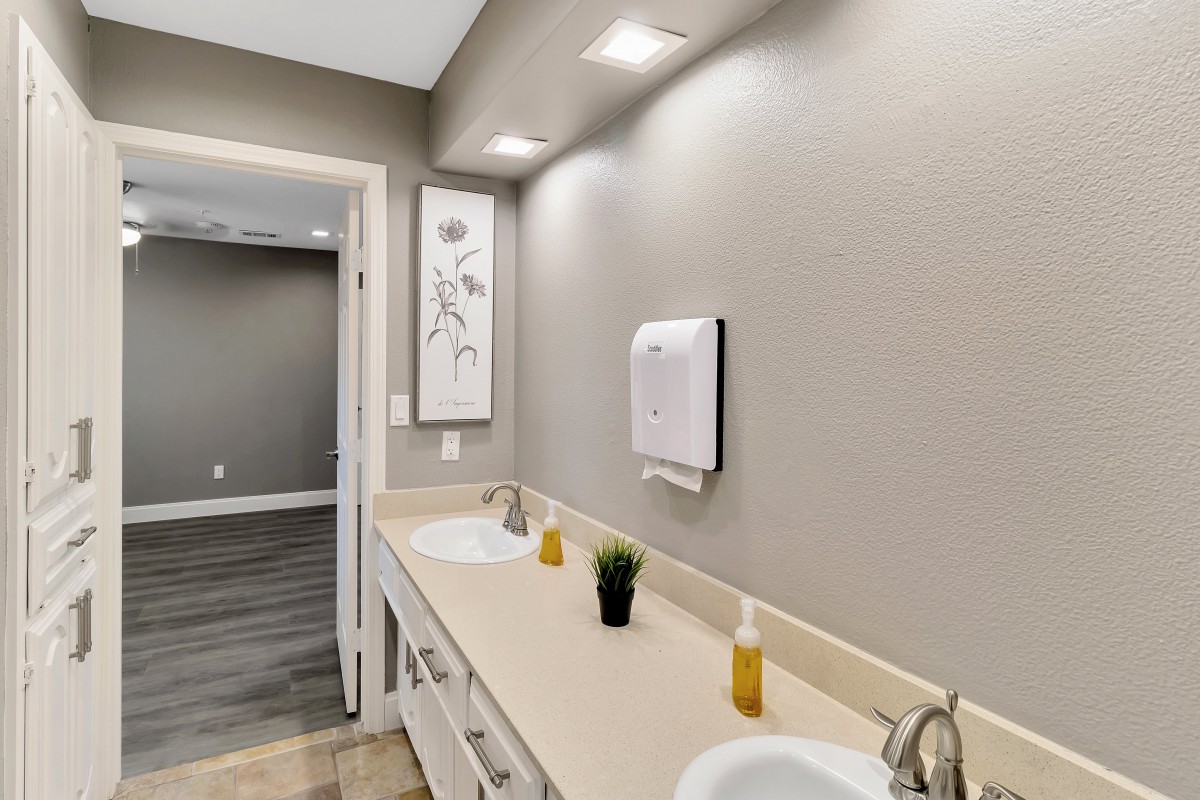 A modern bathroom interior featuring dual sinks, stylish lighting, and minimalist decor.